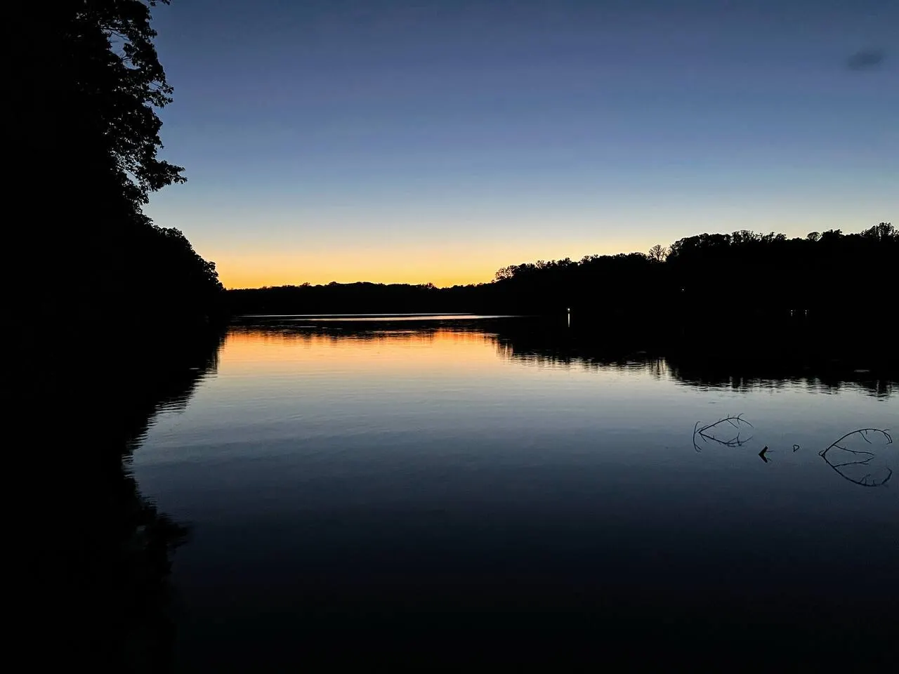 Sunset glowing over the still water of Mayo Lake, seen from the private dock
