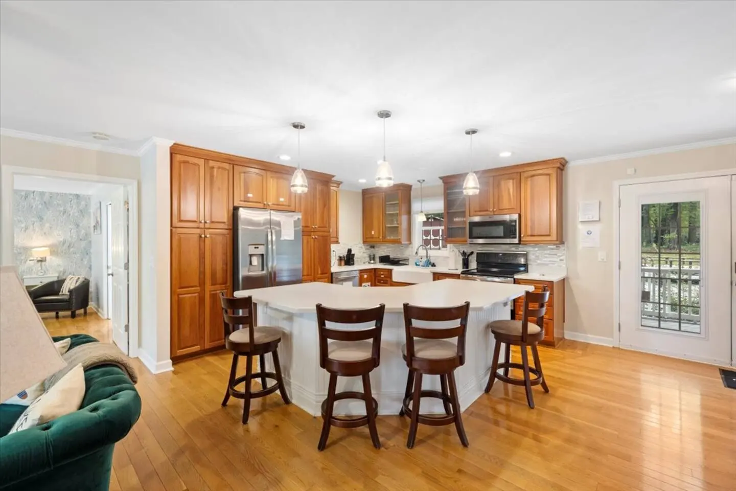 Kitchen island with bar stools opening to the dining area and great room