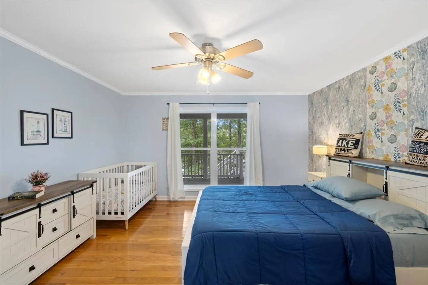 Bedroom with a queen bed and a crib set up for younger guests