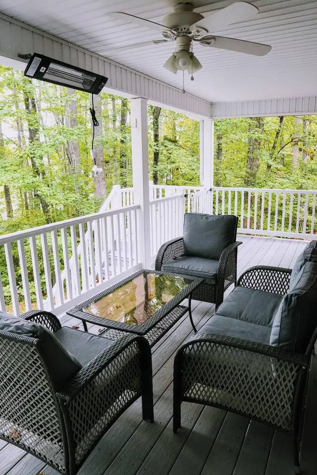 Screened, heated porch with a wicker conversation set facing the trees