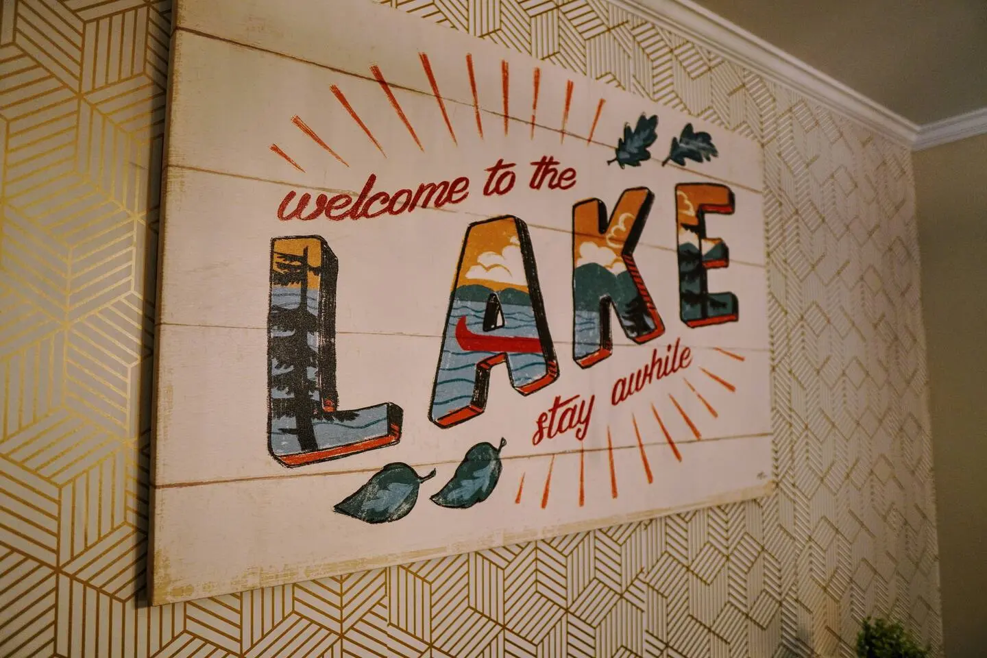 A painted 'Welcome to the Lake, stay awhile' mural on an interior wall