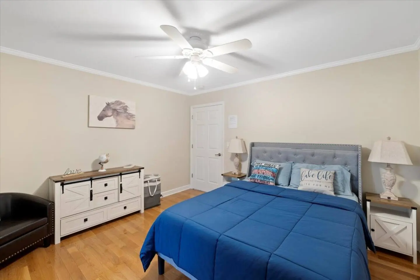 Bedroom with a queen bed, a dresser, and soft accents