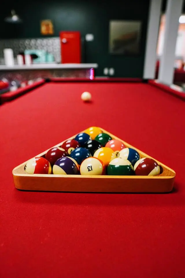 Billiard balls racked on the red-felt pool table