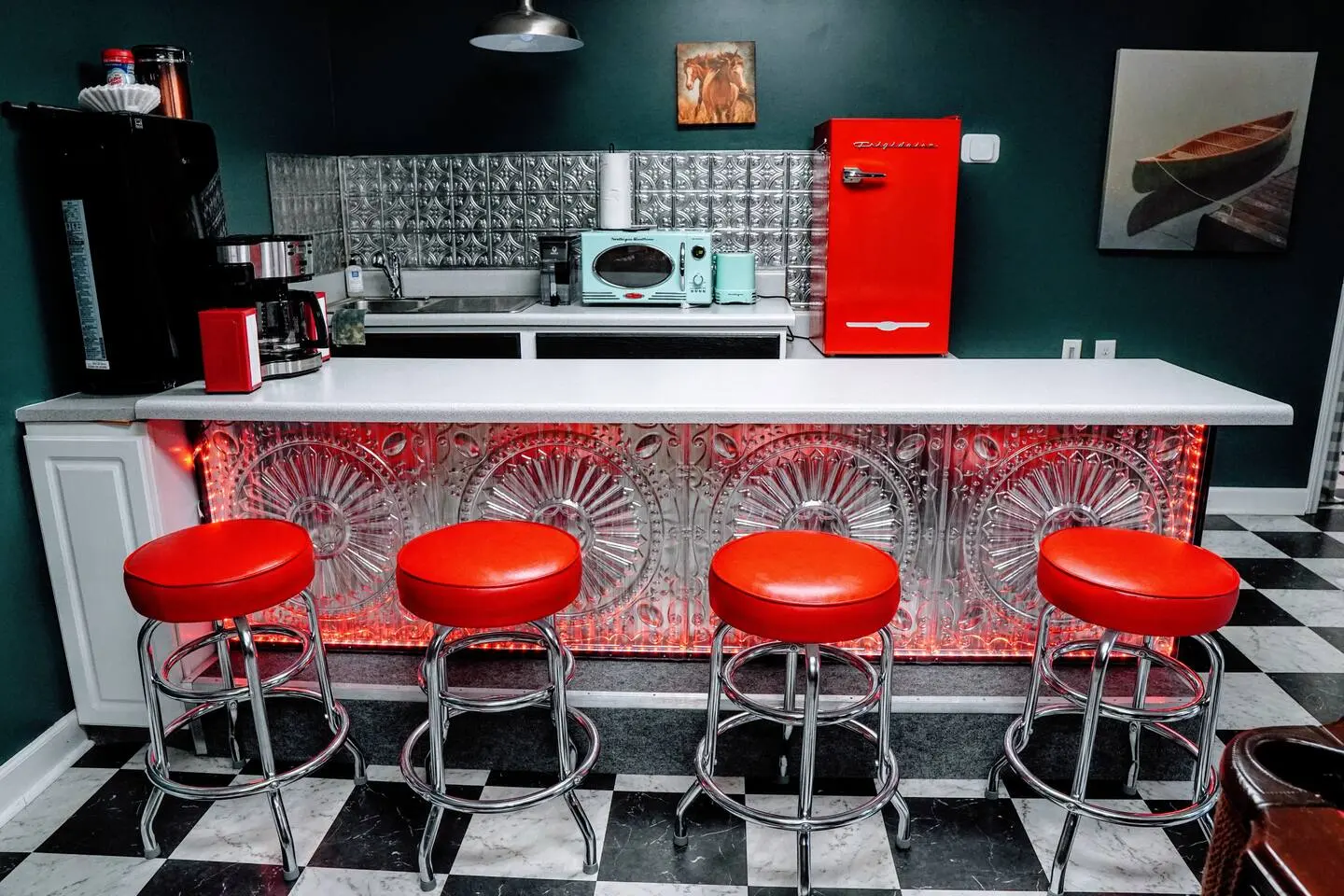 Retro bar with a tin backsplash and four red diner stools